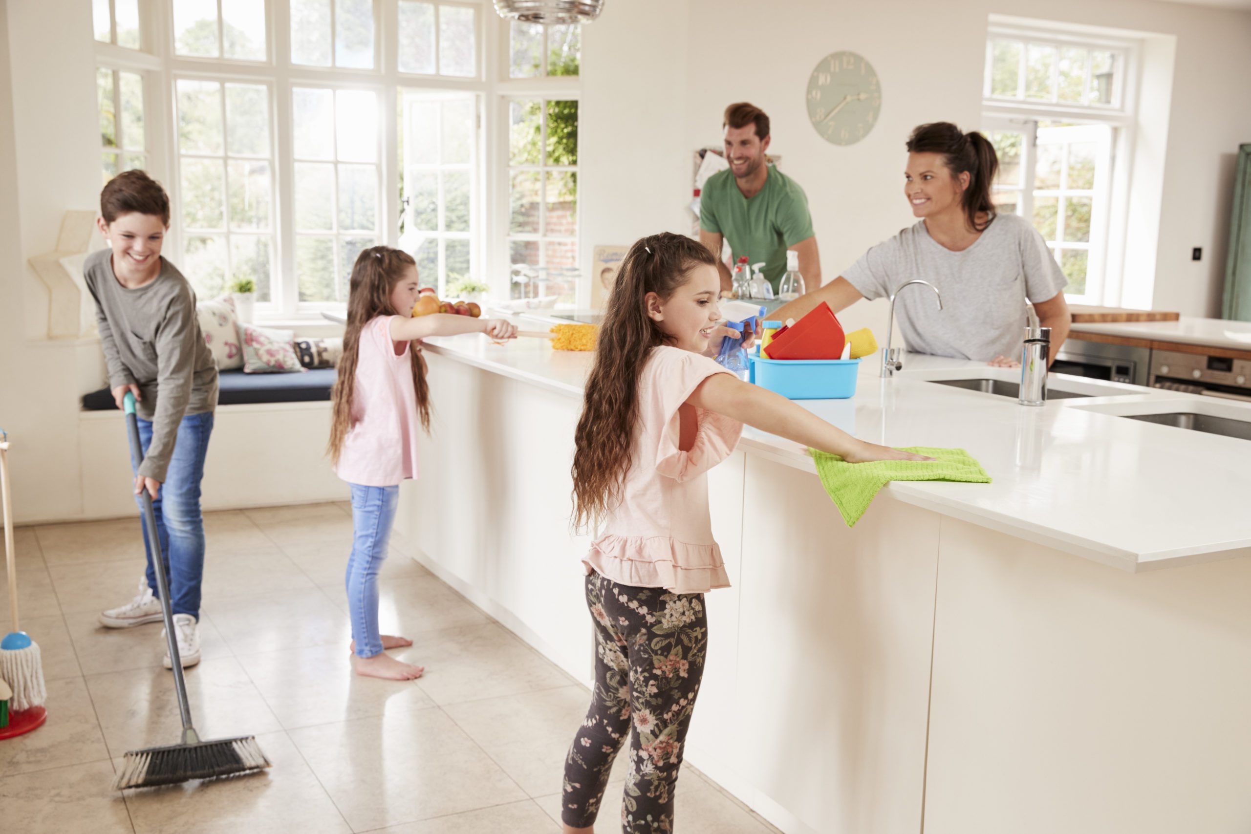 Children Helping Parents With Household Chores In Kitchen
